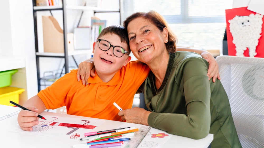 éducatrice avec un jeune heureux durant leur atelier dessin